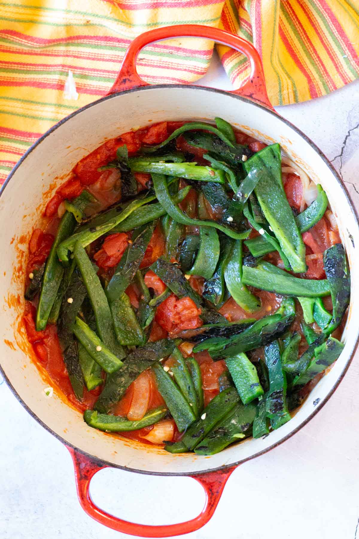 Poblano peppers and tomatoes in a dutch oven to make Mexican short ribs.