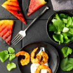 Grilled watermelon wedges with curried shrimp on greek yogurt with a watercress salad