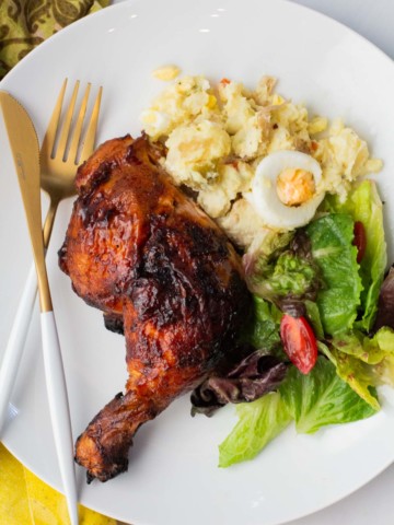 Grilled chicken served with potato salad and a tossed salad.