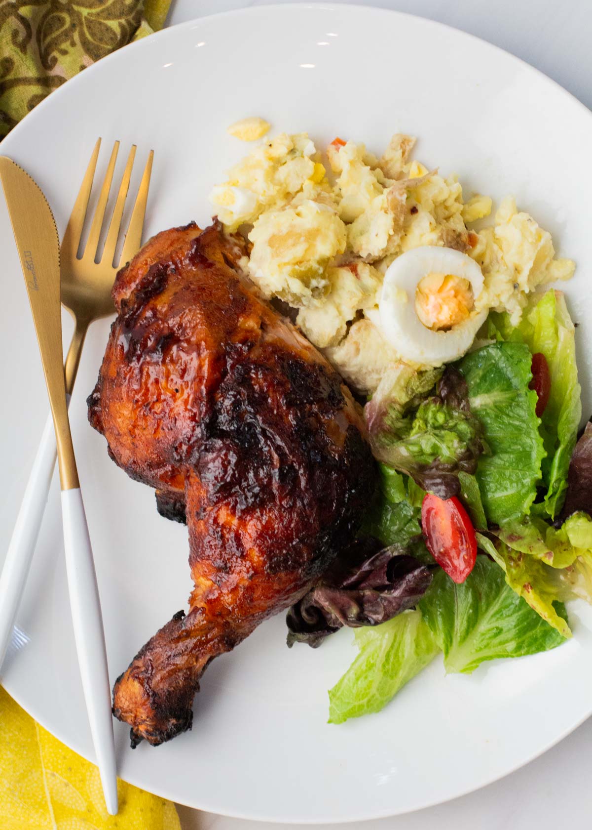 Grilled chicken served with potato salad and a tossed salad.