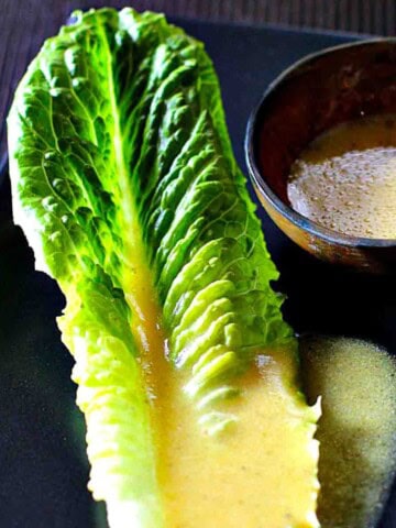 Dijon Vinaigrette on a leaf of Romaine Lettuce.