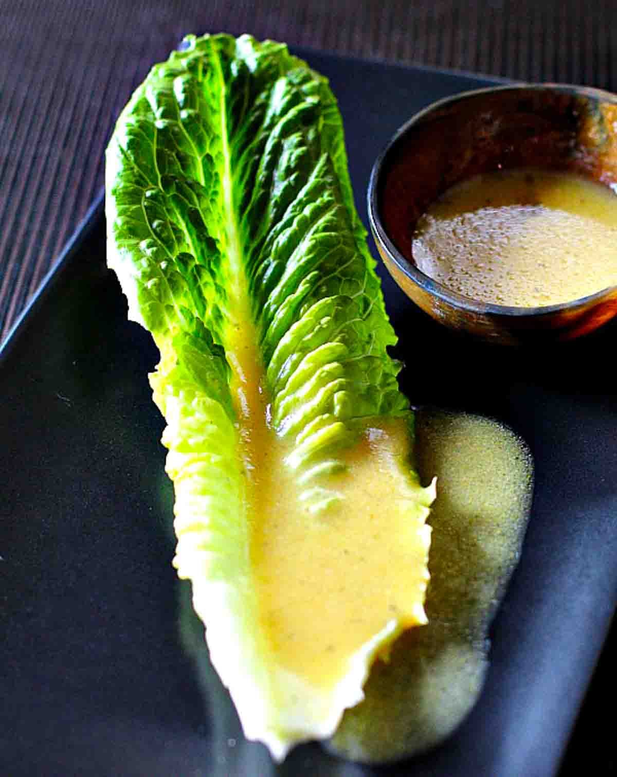 Dijon vinaigrette on a leaf of romaine lettuce.