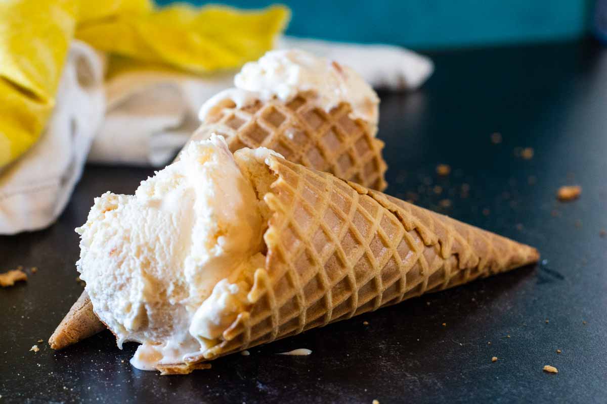 Two homemade peach ice cream cones laying on their side.