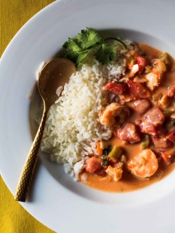 Seafood stew with shrimp and cod served with a side of white rice.