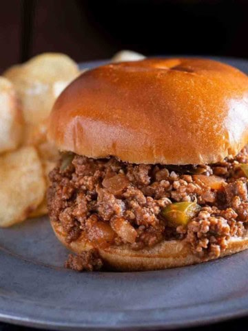 Sloppy joes for a crowd. A sloppy joe served on a plate with potato chips.