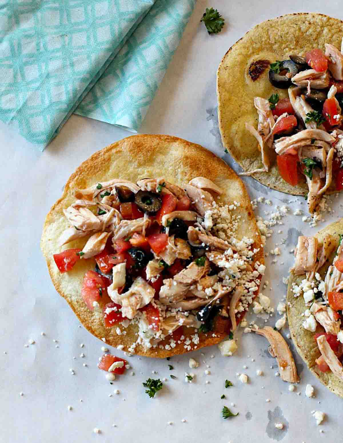 Zesty Chicken Tostadas with Feta Cheese, olives and tomatoes.
