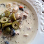 Creamy olive soup with chicken and white rice topped with sliced olives