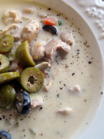 Creamy olive soup with chicken and white rice topped with sliced olives