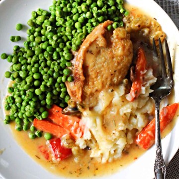 Chicken marengo chicken thighs served with peas and mashed potatoes