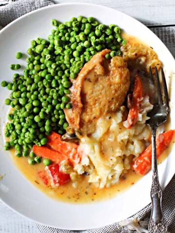 Chicken marengo chicken thighs served with peas and mashed potatoes