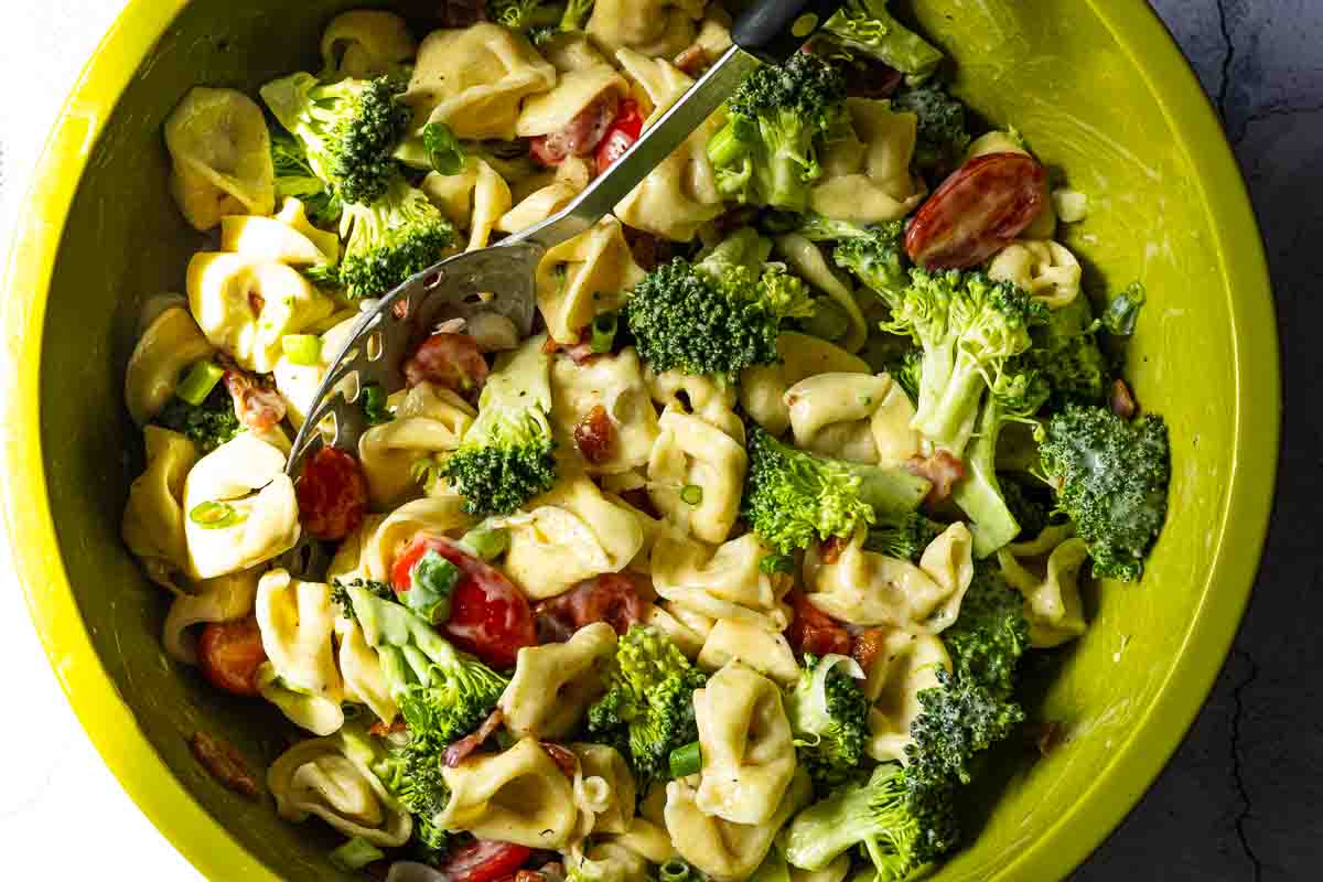 Cheese tortellini pasta salad ingredients combined.