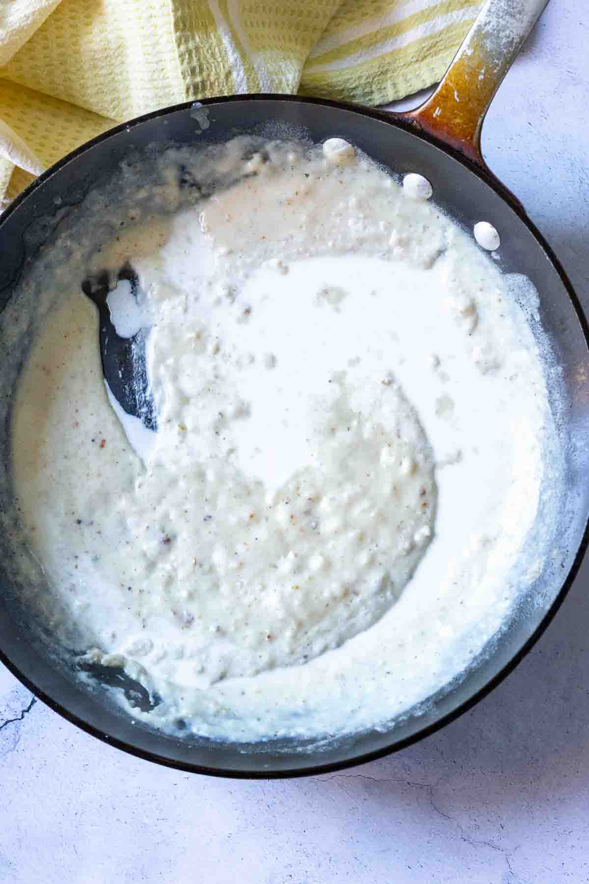 Stirring in milk to thini fried chicken gravy.