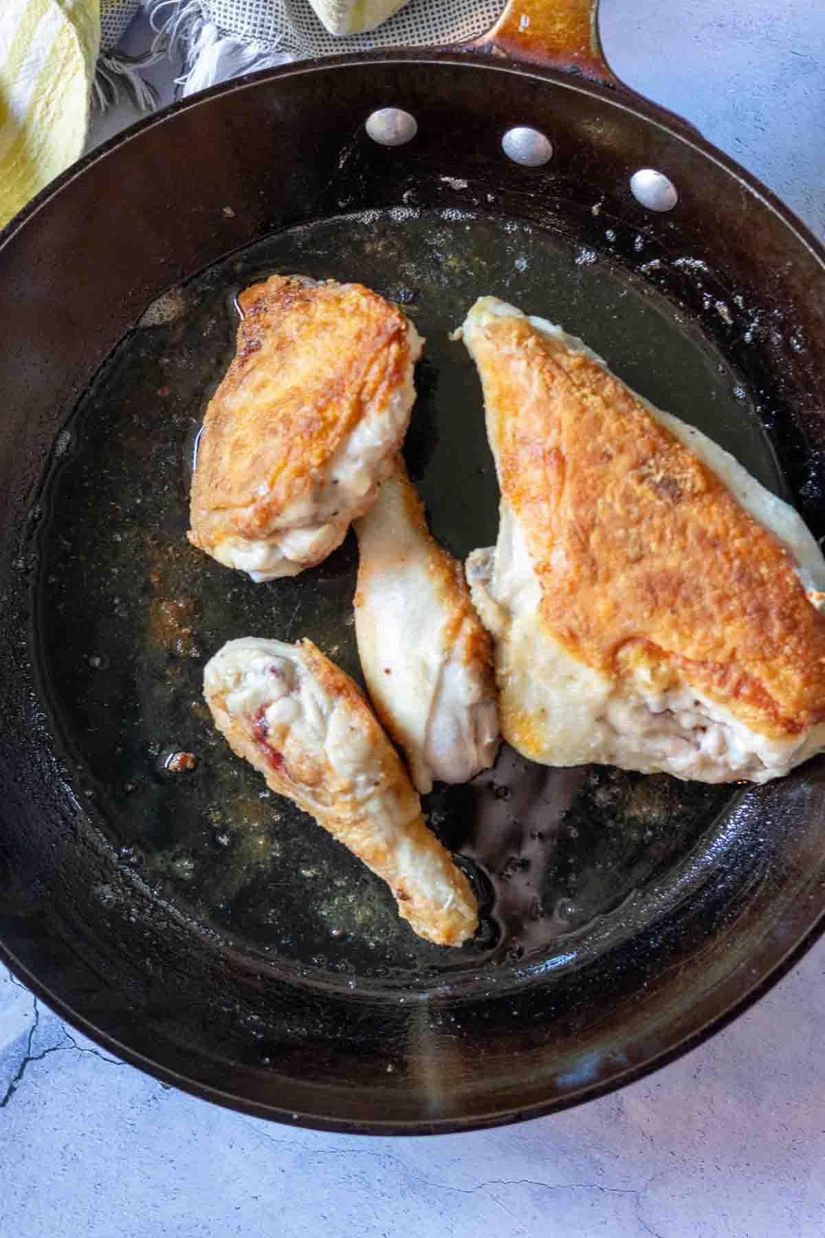 Cooking chicken pieces in crisco to make pan fried chicken.