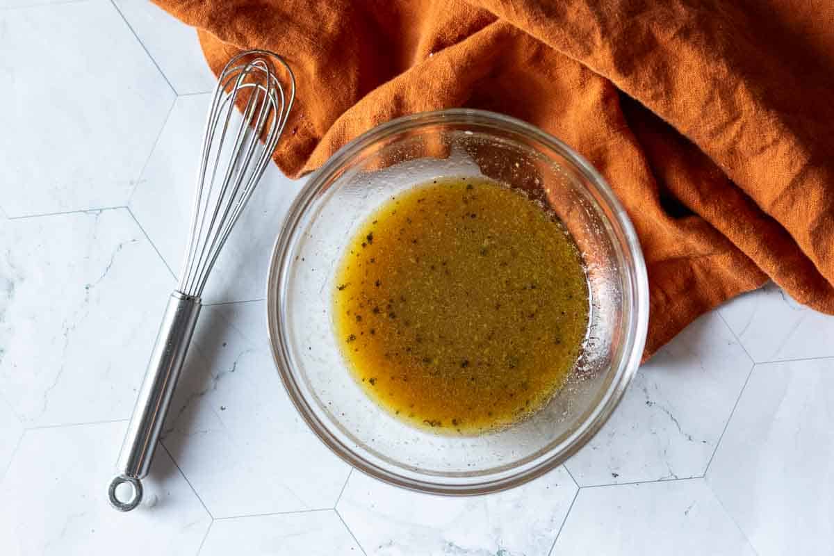 Heating maple syrup vinaigrette in a glass bowl for butter bean salad.