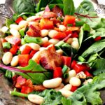 bacon, white bean, spinach salad recipe. With maple vinaigrette served on a silver platter