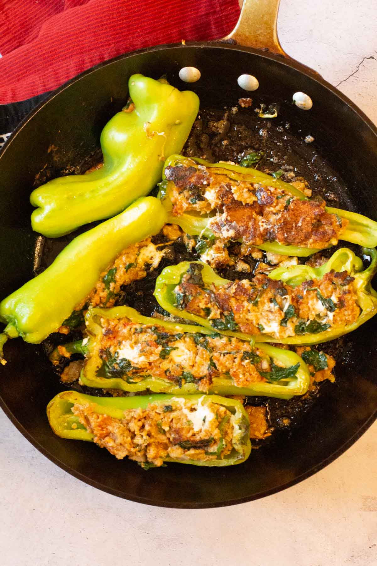Frying Italian Peppers stuffed with Italian Sausage and Spinach.