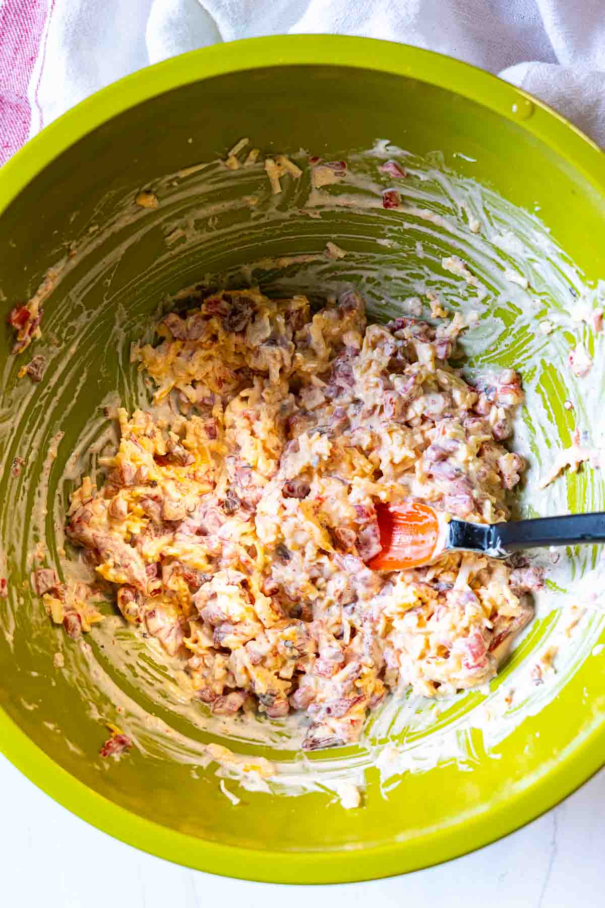 Mixing all ingredients together to make spicy pimento cheese spread.