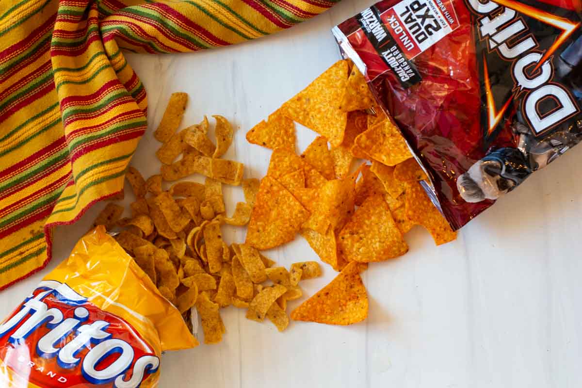 Packages of Doritos and Fritos with chips coming from the top