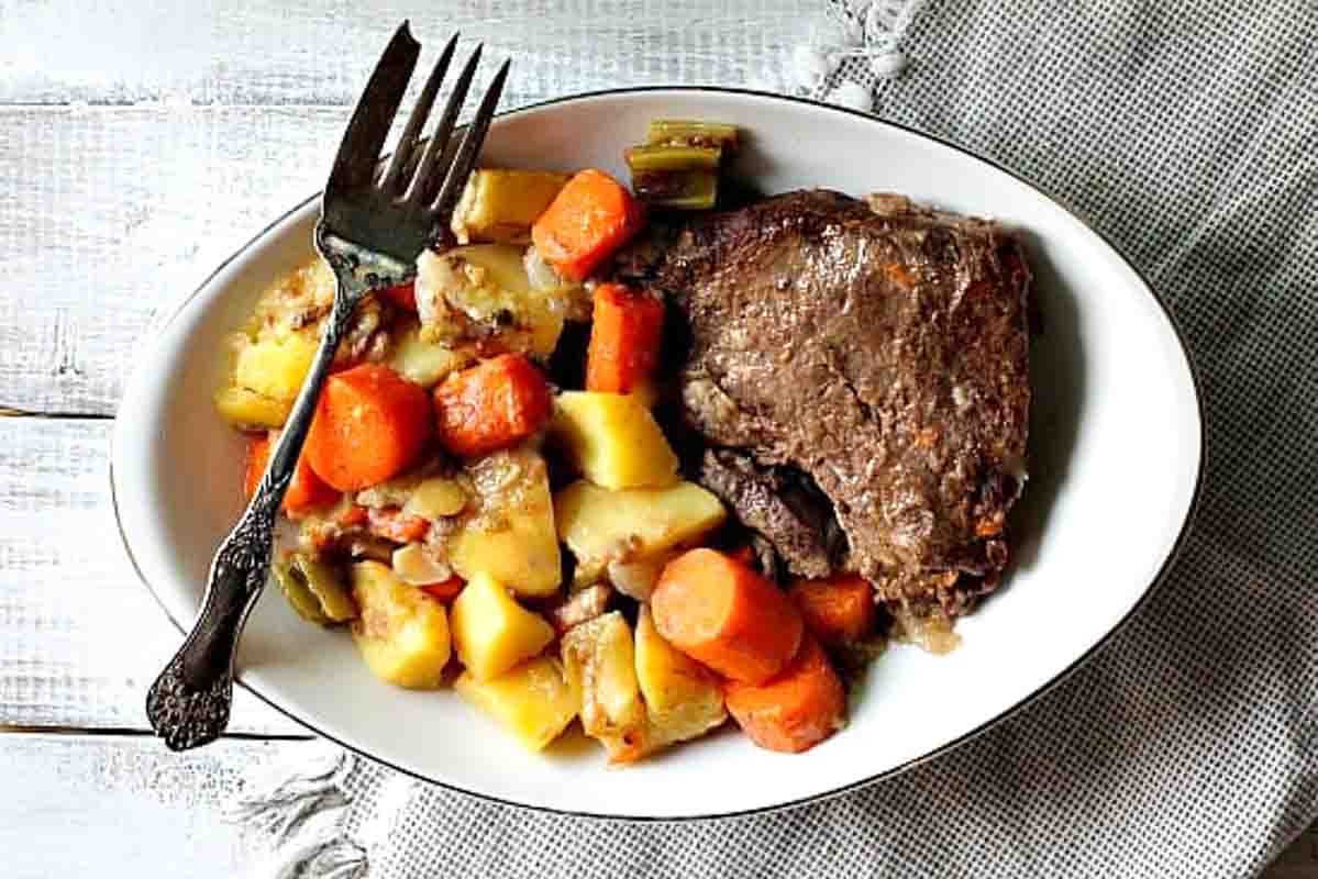 Old Fashioned Pot roast dinner with carrots and potatoes.