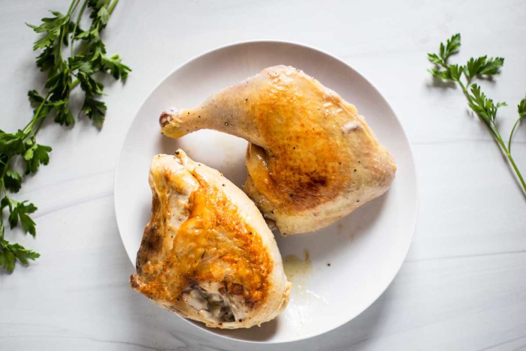 Seared chicken quarters on a plate