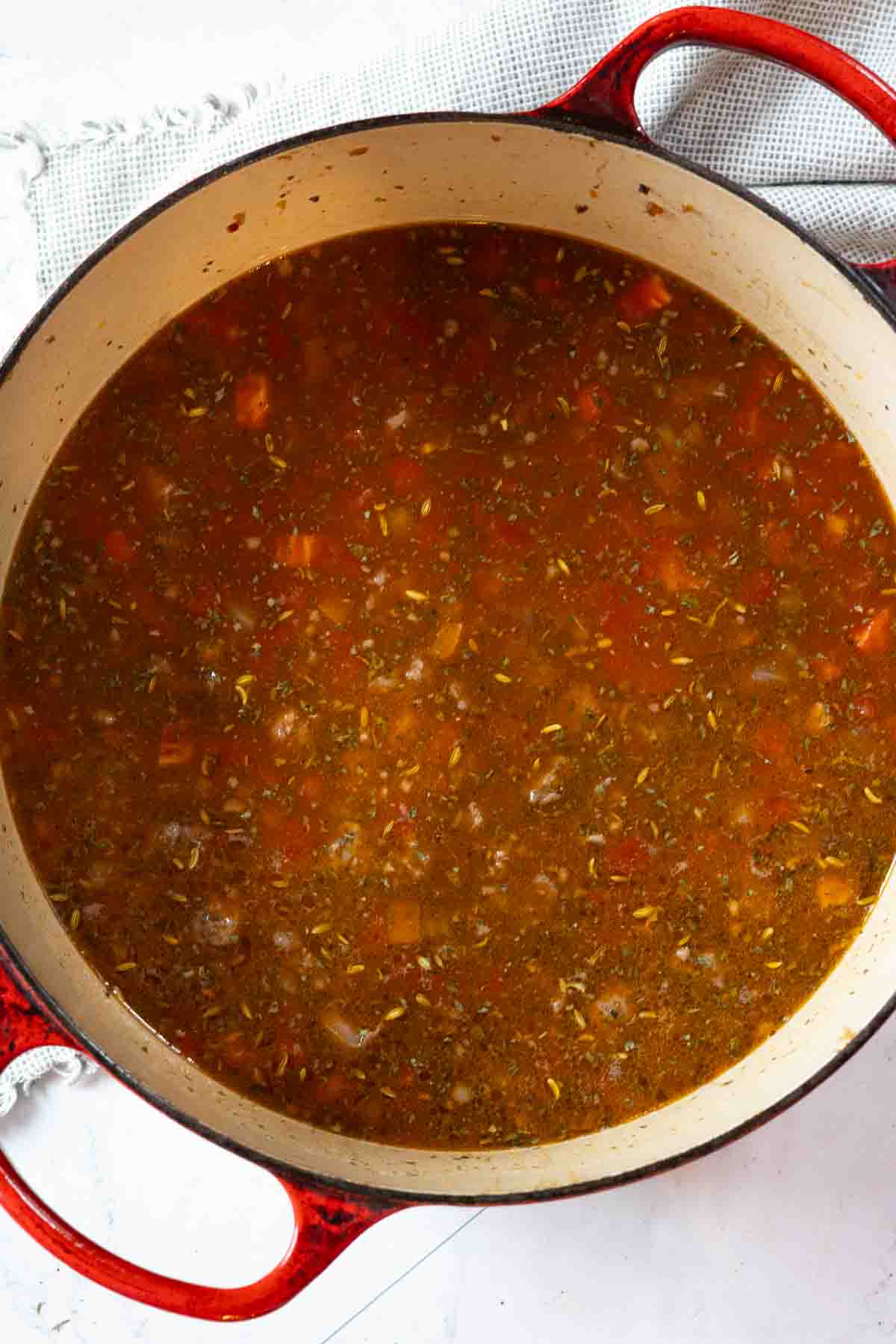 Step 5: Adding beef broth to ingredients to make Italian Sausage Soup.