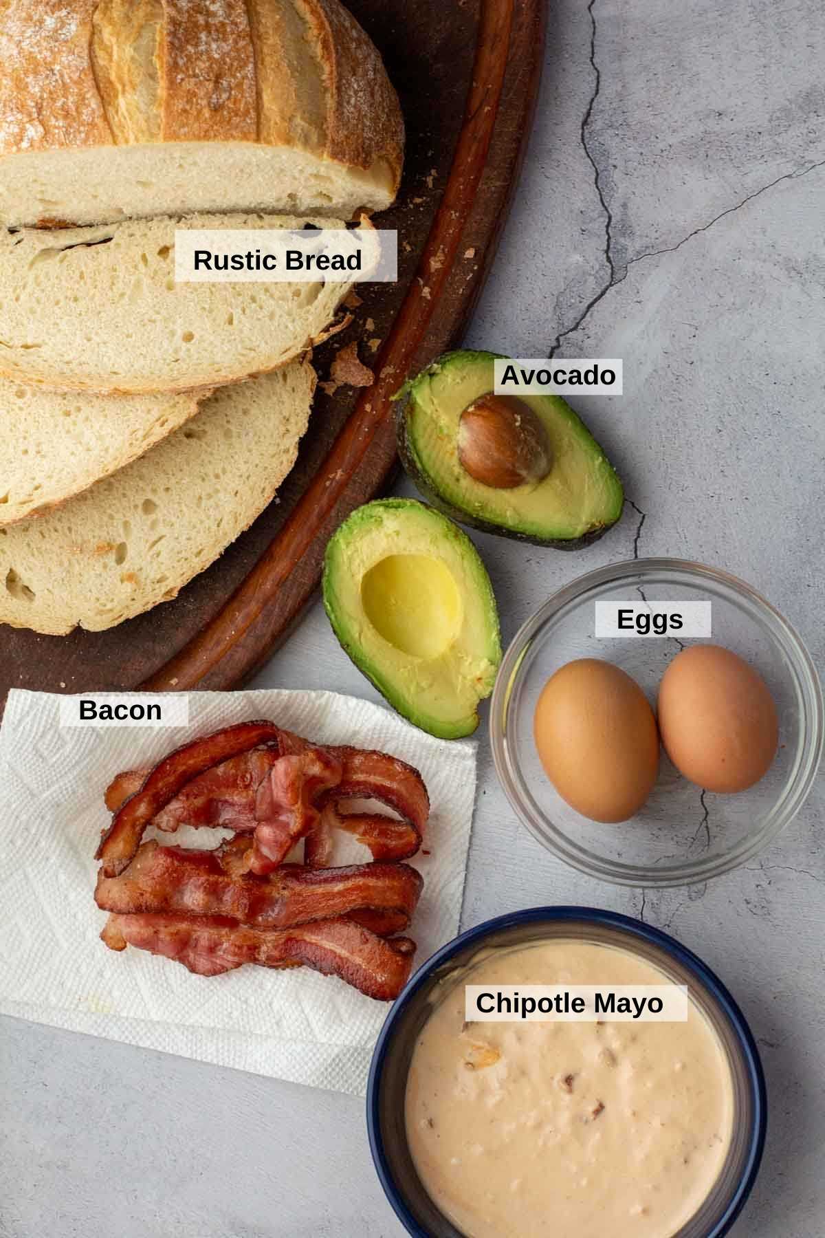 Ingredients to make bacon, egg and avocado breakfast sandwich.