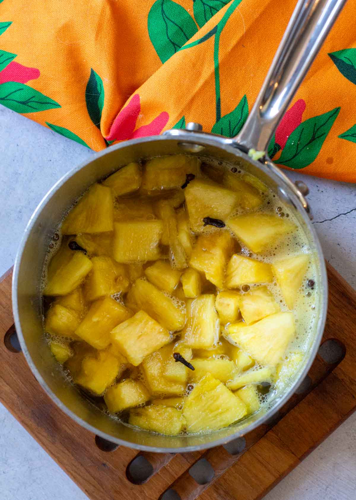Cooking pineapple chunks in pickled pineapple syrup solution.