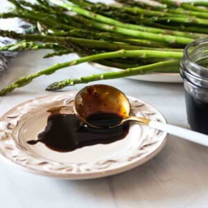 Balsamic redcution sauce on a white plate.