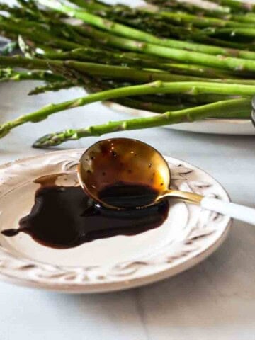 Balsamic redcution sauce on a white plate.