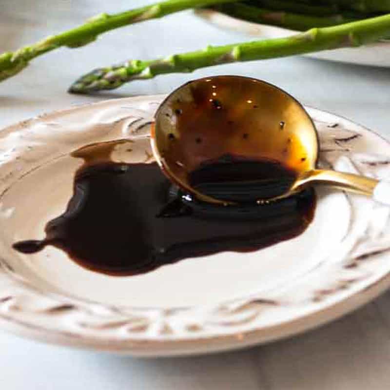 Balsamic reduction sauce coating a spoon.