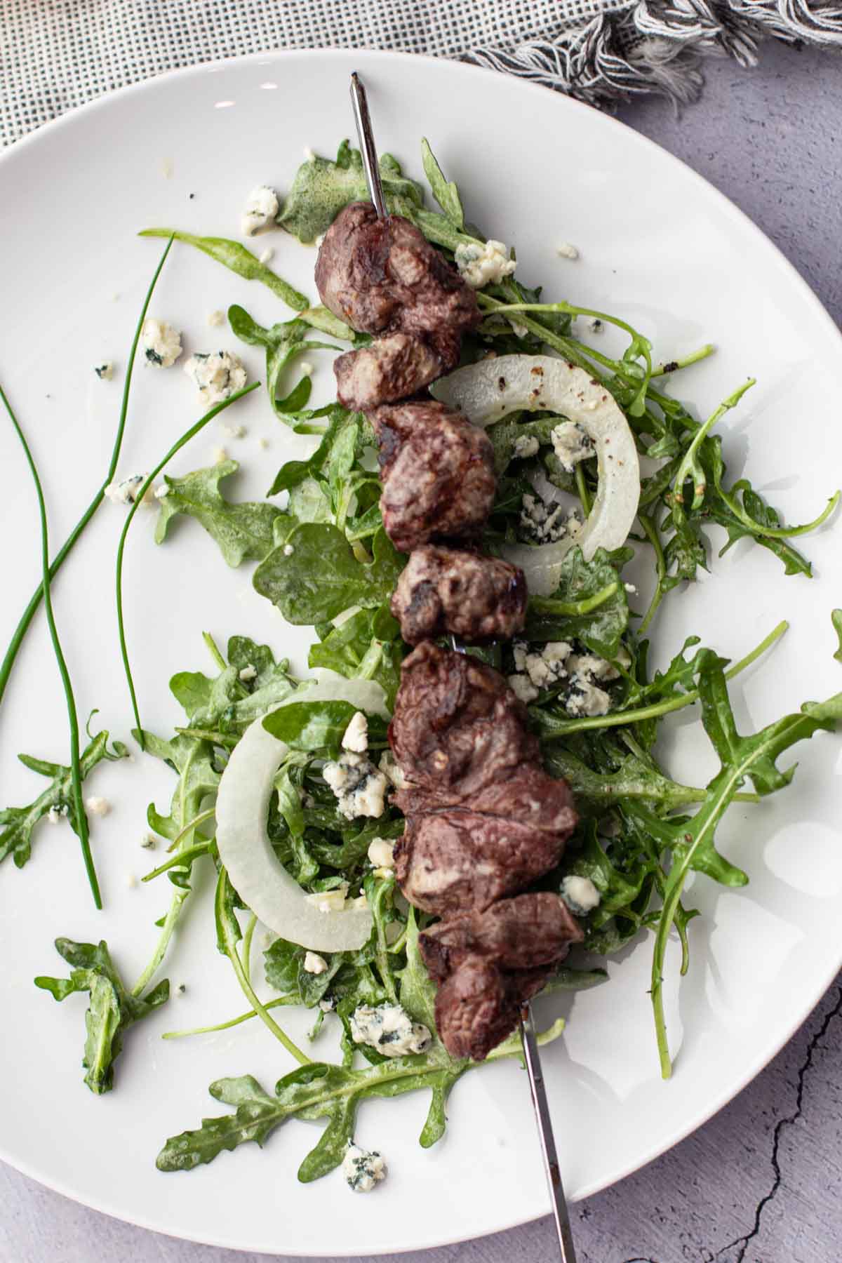 Grilled Lamb Kebab Salad with sweet onions, arugula and blue cheese.