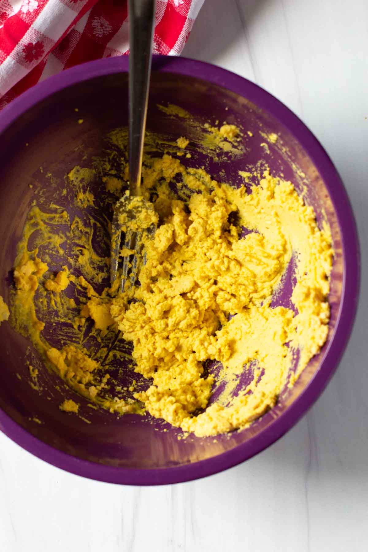 Combing mustard and egg yolk to make dressing for Amish macaroni salad.