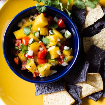 Pico de gallo with mango served blue and white corn chips.