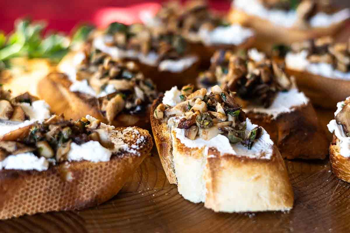 Slices of mushroom bruschetta appetizer with goat cheese.