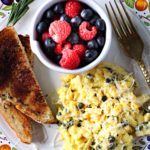 Scrambled eggs with capers served with toast and fresh berries