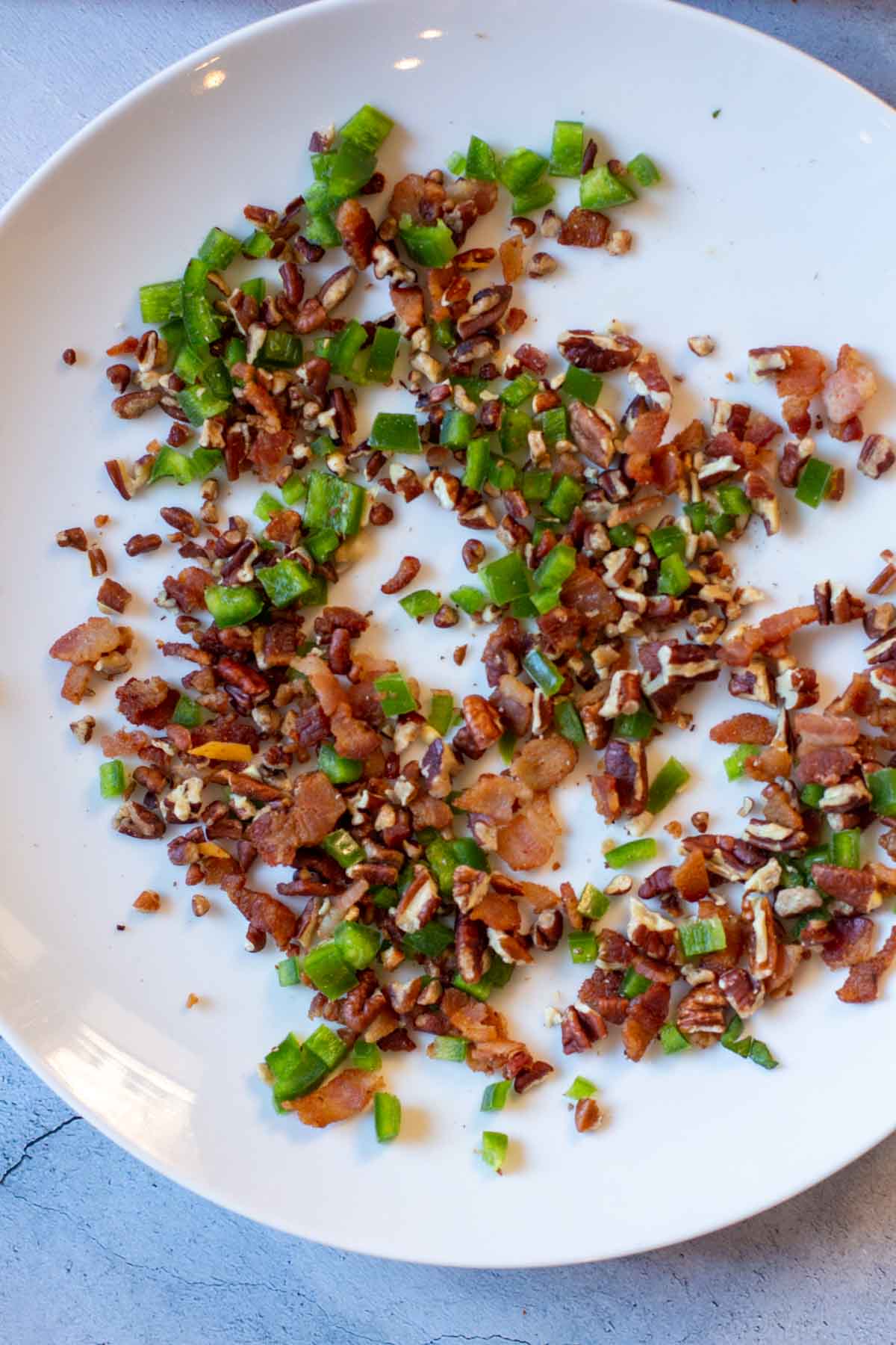 Bacon, jalapeno and pecans on a plate.