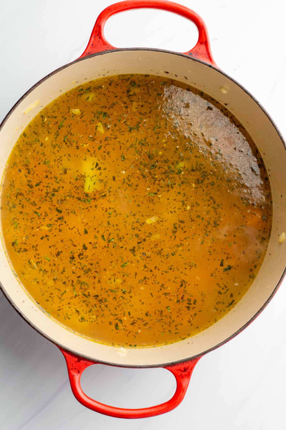 Adding spices to sweet potato chicken soup.