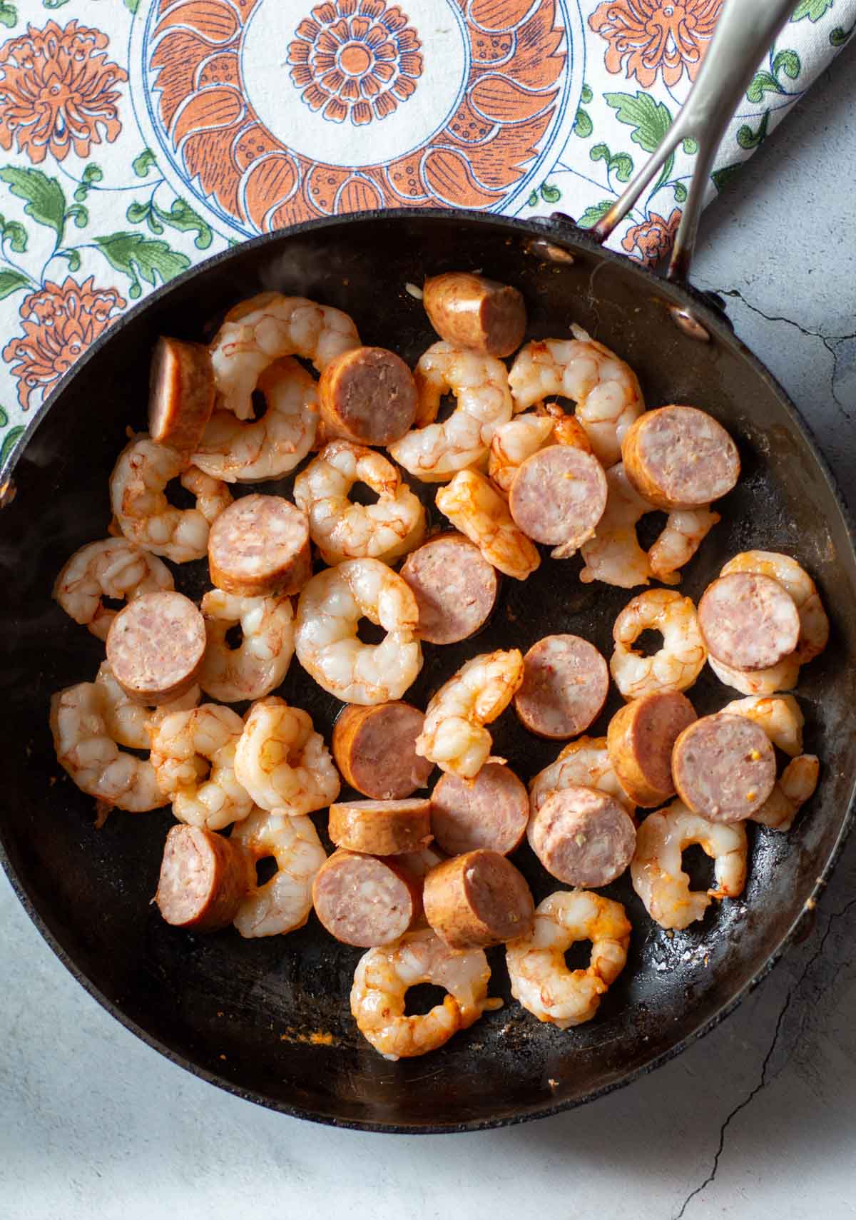 Cooking shrimp and sausage to make spicy paella.