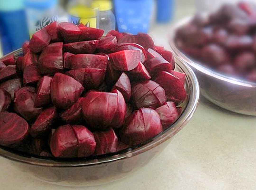 A bowl of peeled and pickled beets.