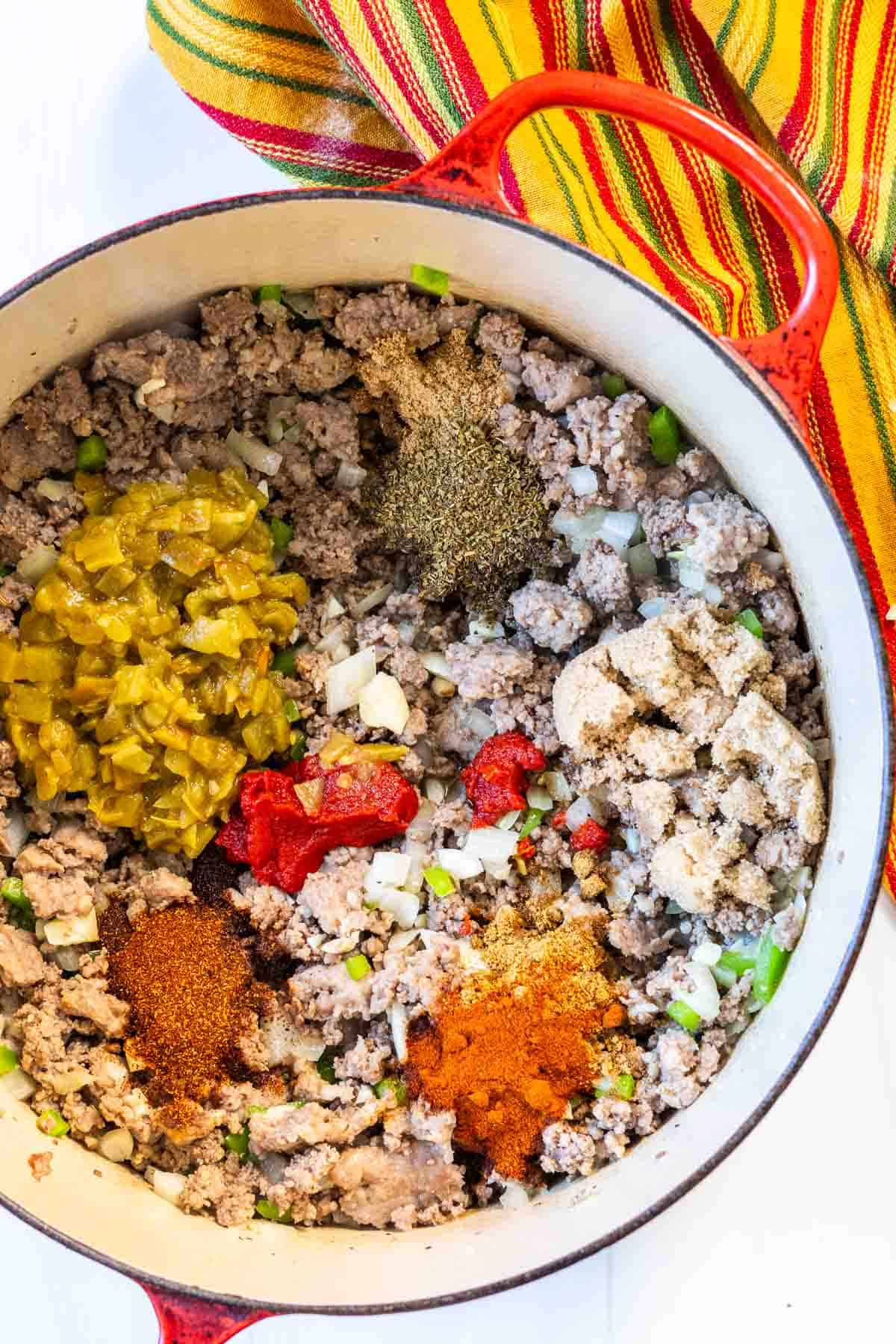 Adding spices to meat mixture to make award winning chili.