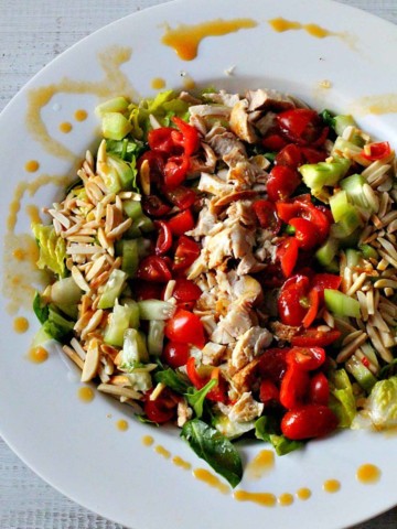 Grilled chicken chopped salad in a large white flat salad bowl.