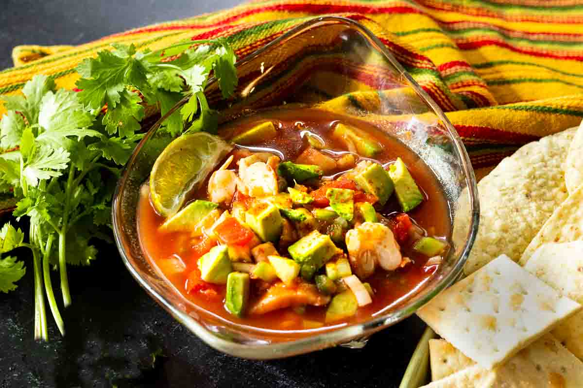 Campechana in a glass bowl served with tortilla chips and saltine crackers.