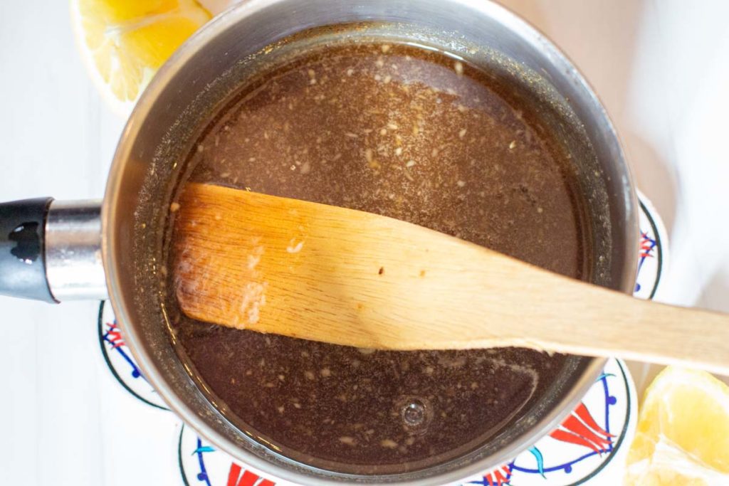 Grilled ham steak glazed cooking in a small saucepan