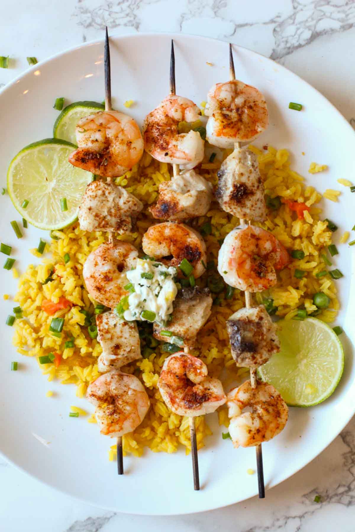 Shrimp and mahimahi kabobs served over yellow rice with a dollop of jalapeno butter.