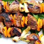 Beef sirloin steak kabobs with orange bell peppers and green onions