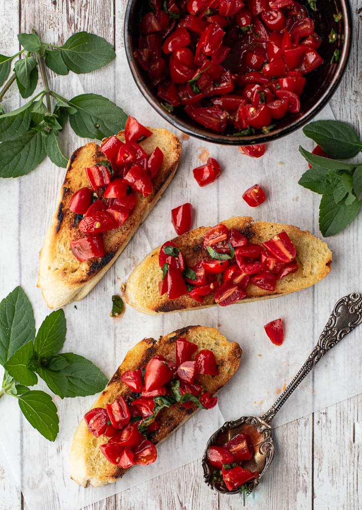 Toasted sliced baguettes topped with fresh tomatoes and chopped basil
