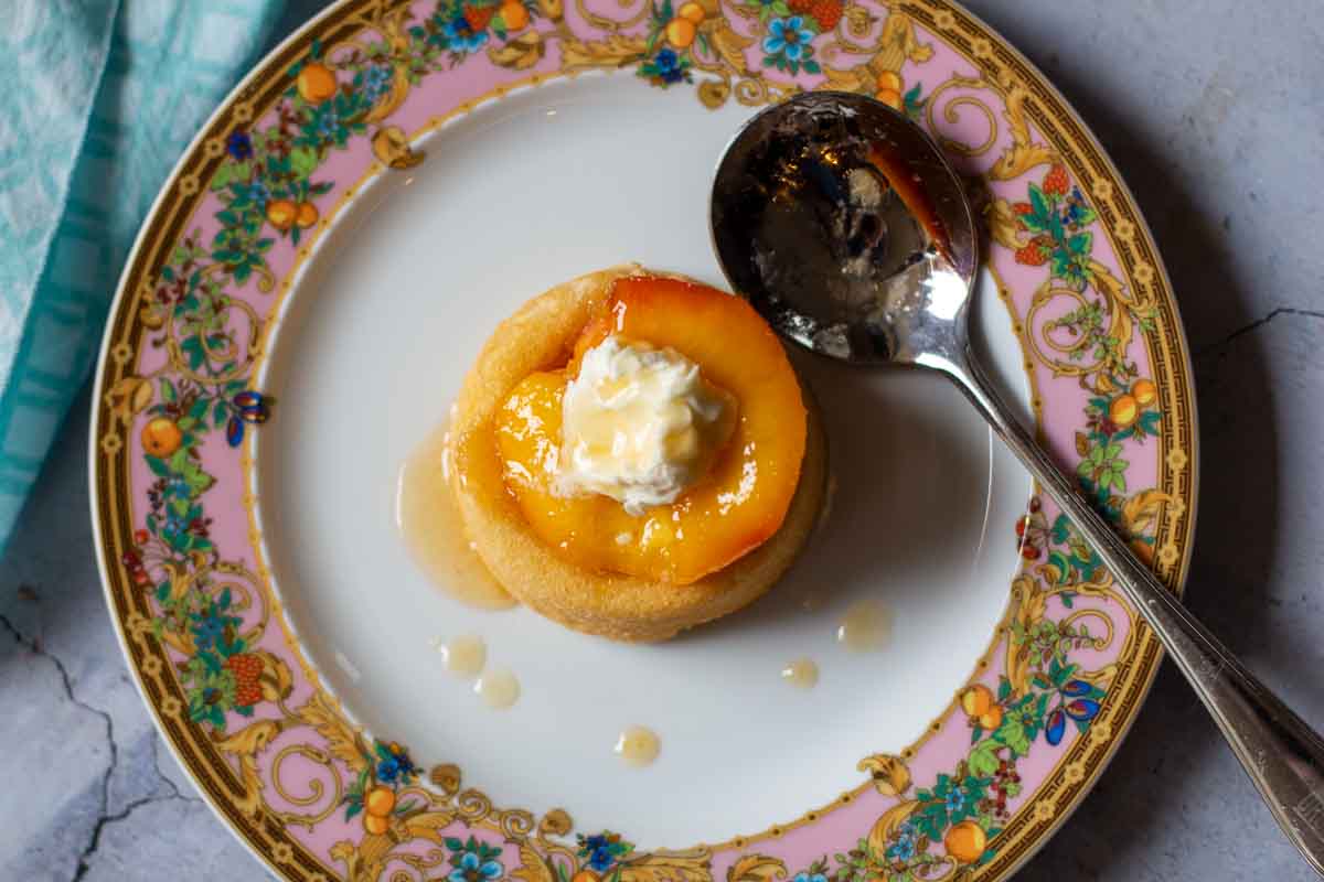 Roasted peaches with mascarpone cheese on a dessert shell drizzled with vanilla butter sauce.
