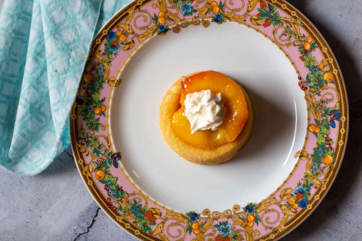 A roasted peach on a vanilla dessert shell topped with mascarpone cheese.