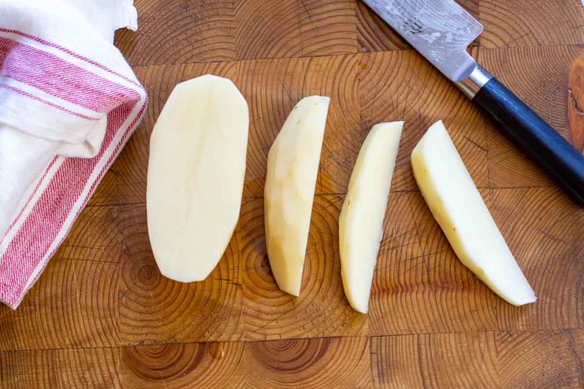 Cutting a potato into fourths to make oven fry wedges.