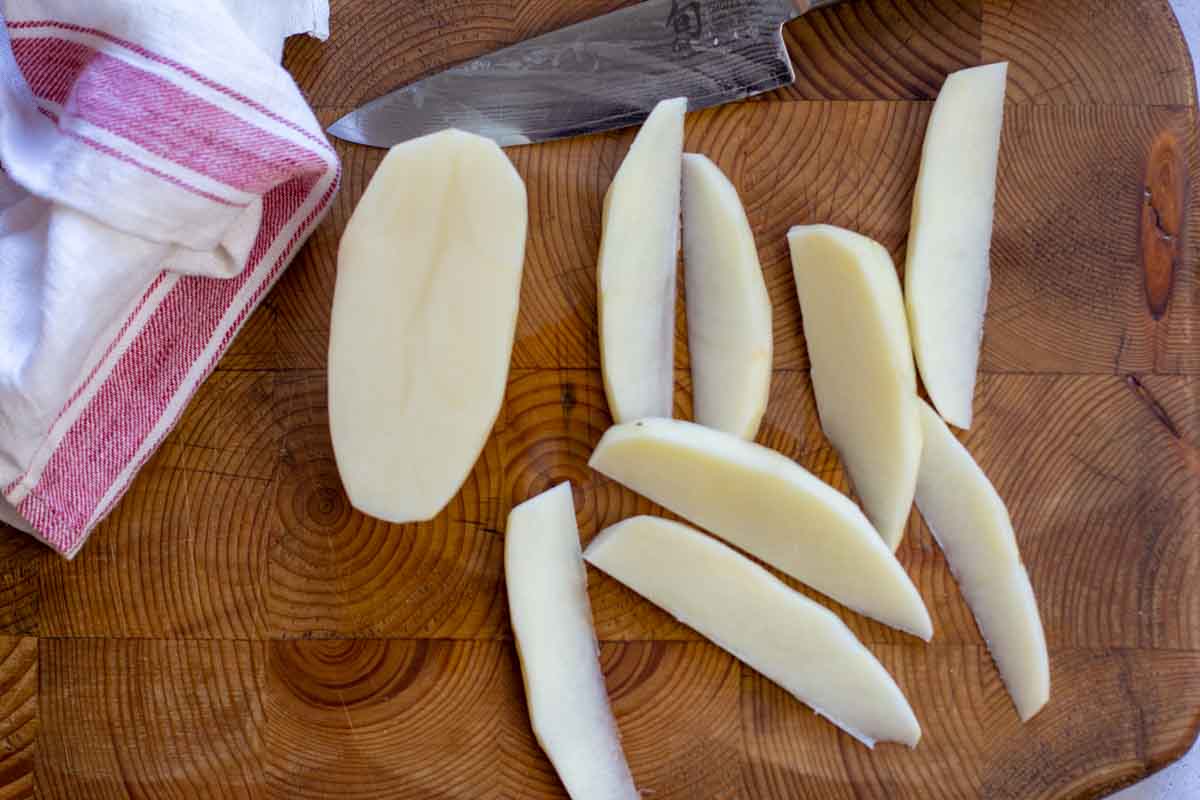 Cutting a potato into eights to make potato wedges.